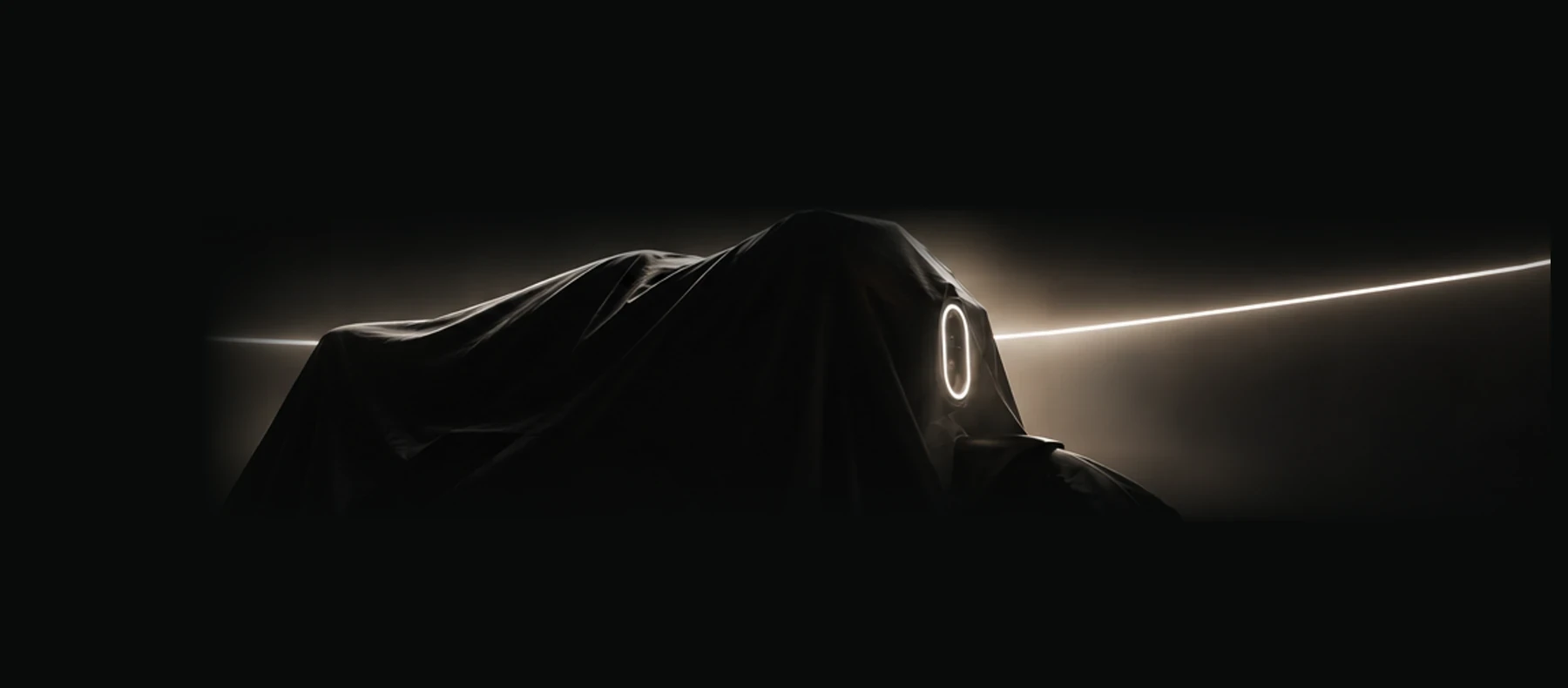 The silhouette of a future electric motorcycle hidden beneath a dark cover